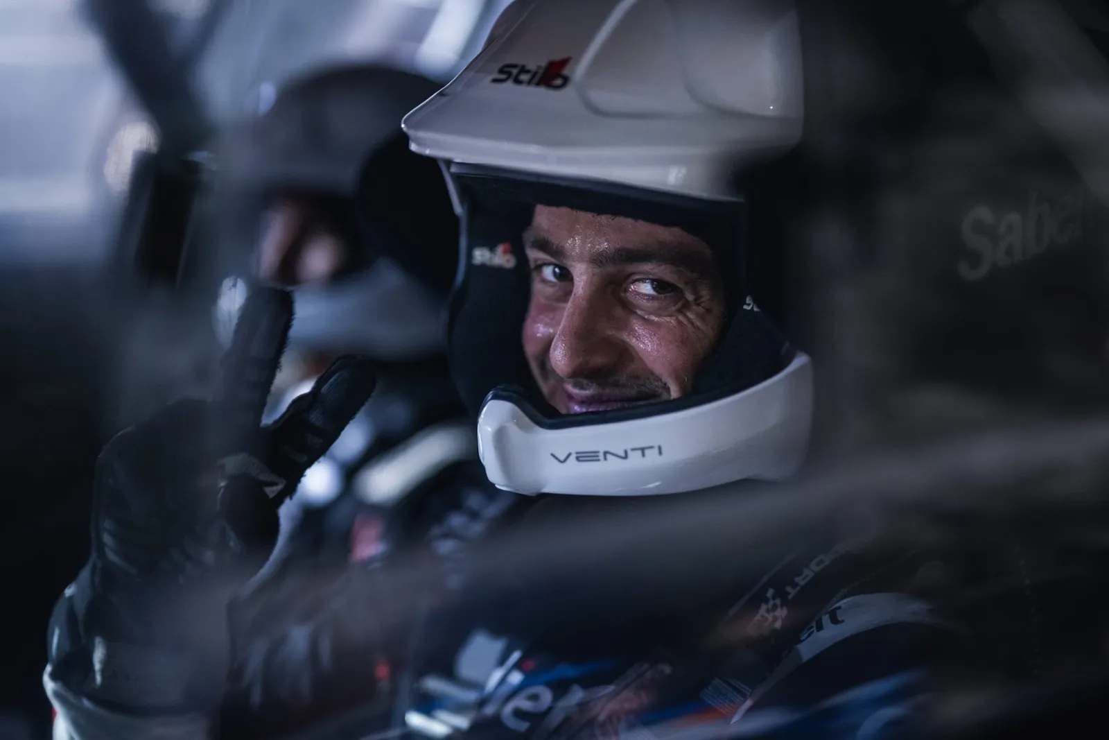 Carl Rizk strapped into the rally car, helmet on
